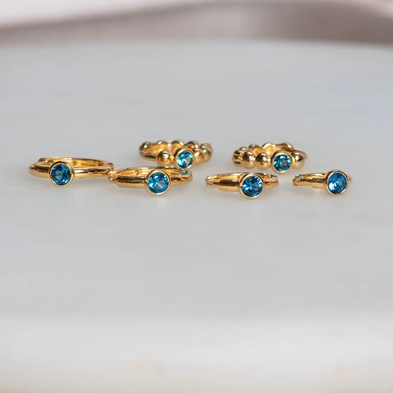 Bezel Set Blue Topaz Huggie in 14k Gold